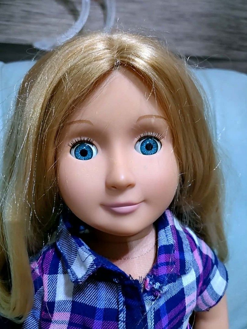 Our Generation Doll with Plaid Outfit (Category: Kids Toys) located in Baliuag. Submitted by marieannfernando23 (Listing ID 1461289059, Image 2). Description: - Our Generation doll - Long blonde hair - Bright blue eyes - Blue and purple plaid shirt dress with white lace trim - Pink cord belt - Pink bracelet on left wrist - Ready for a new home!.