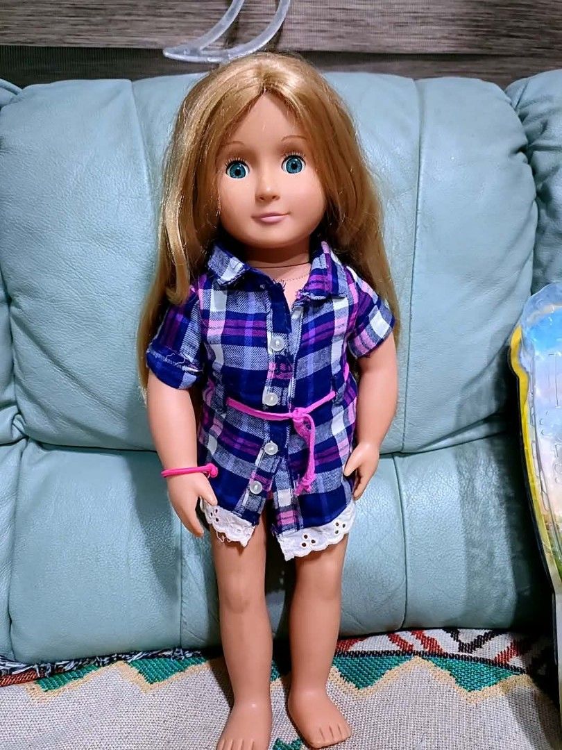 Our Generation Doll with Plaid Outfit (Category: Kids Toys) located in Baliuag. Submitted by marieannfernando23 (Listing ID 1461289059, Image 1). Description: - Our Generation doll - Long blonde hair - Bright blue eyes - Blue and purple plaid shirt dress with white lace trim - Pink cord belt - Pink bracelet on left wrist - Ready for a new home!.