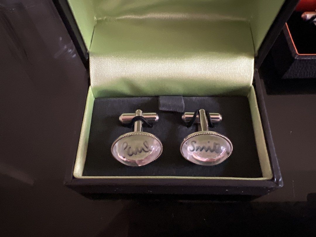 Paul Smith Cufflinks - Two Pairs (Category: Cuff Links) located in Manila. Submitted by mikimae777 (Listing ID 1461168413, Image 2). Description: - Authentic Paul Smith cufflinks - Two distinct styles available: - Engraved 'Paul Smith' on oval stones - Blue flower design under glass - Both pairs come with original Paul Smith boxes - Ideal accessories to complete your formal wear.