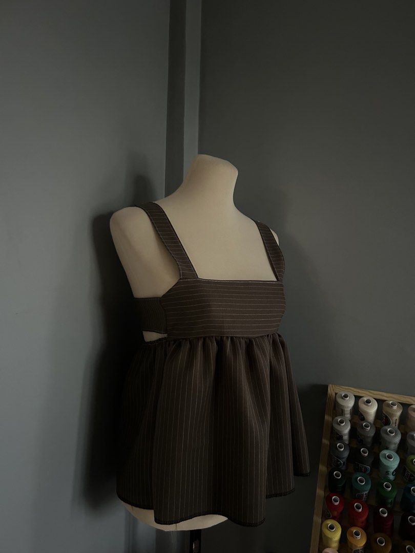 Pinstripe Square Neck Babydoll Top (Category: Sleeveless) located in Banaybanay. Submitted by rethread.co (Listing ID 1461118167, Image 3). Description: - Brown pinstripe babydoll top - Square neckline with adjustable straps - Gathered waist for a flowy silhouette - Unique side cutouts - Versatile: pairs well with jeans or skirts.