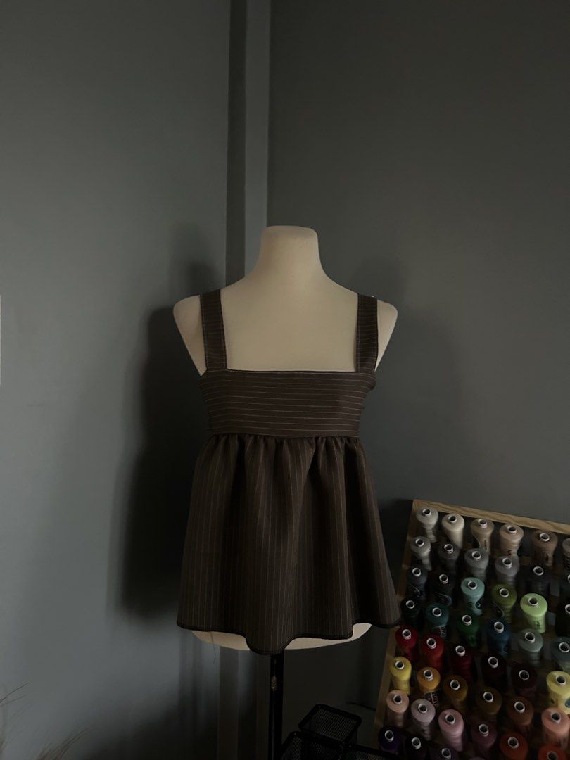 Pinstripe Square Neck Babydoll Top (Category: Sleeveless) located in Banaybanay. Submitted by rethread.co (Listing ID 1461118167, Image 1). Description: - Brown pinstripe babydoll top - Square neckline with adjustable straps - Gathered waist for a flowy silhouette - Unique side cutouts - Versatile: pairs well with jeans or skirts.