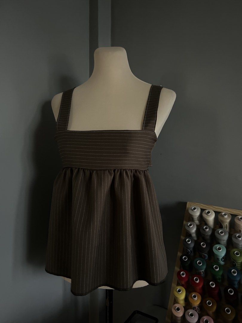 Pinstripe Square Neck Babydoll Top (Category: Sleeveless) located in Banaybanay. Submitted by rethread.co (Listing ID 1461118167, Image 2). Description: - Brown pinstripe babydoll top - Square neckline with adjustable straps - Gathered waist for a flowy silhouette - Unique side cutouts - Versatile: pairs well with jeans or skirts.
