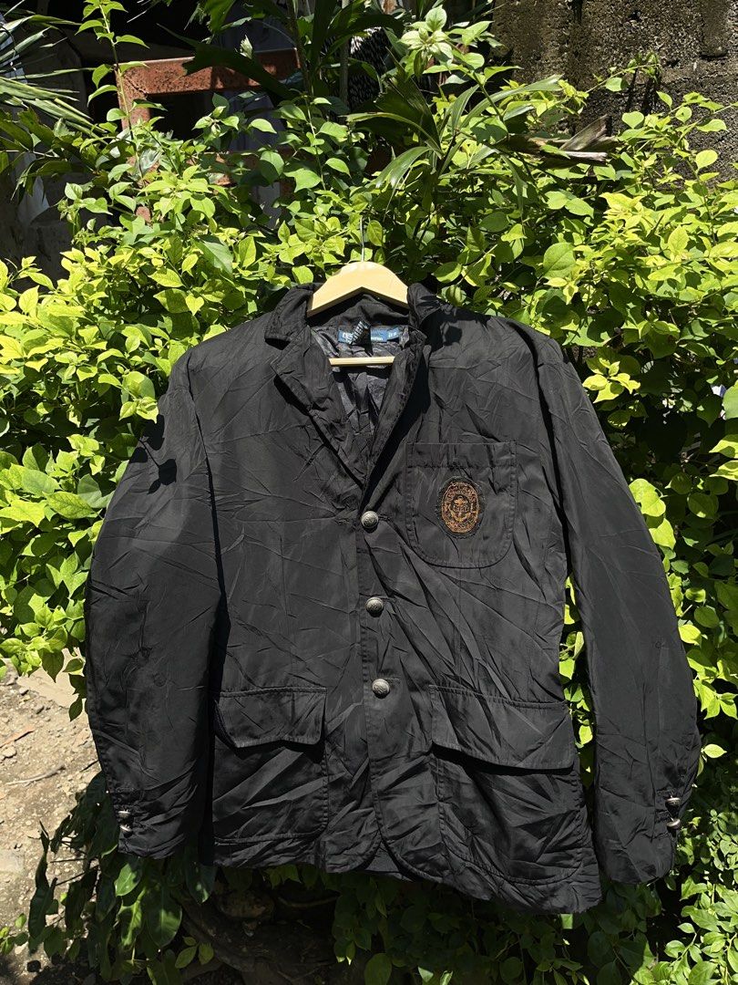 Polo Ralph Lauren Black Blazer Jacket (Category: Coats, Jackets and Outerwear) located in Pontevedra. Submitted by thrift01 (Listing ID 1461183647, Image 1). Description: Black blazer from Polo by Ralph Lauren. Features silver buttons with a crest design. Has two front pockets and an embroidered crest on the chest. Shell is 60% polyester, 40% polyester. Sleeve lining is 100% viscose. Tagged size S. Made in China..