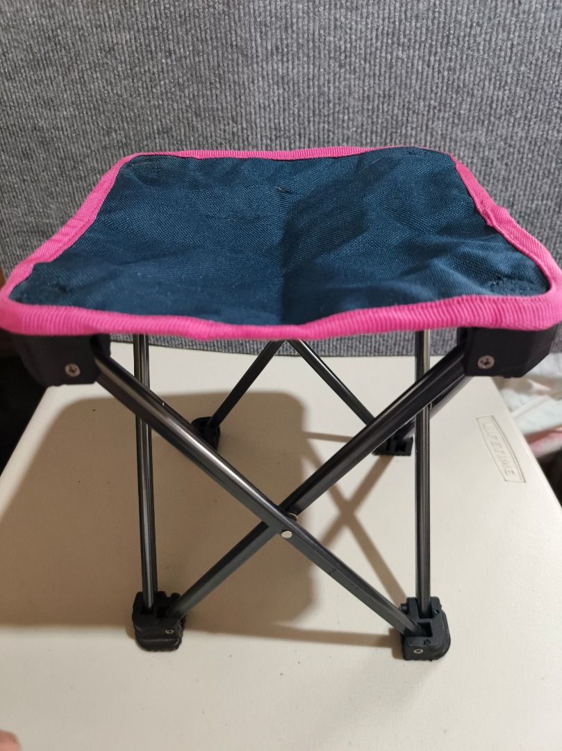 Portable Folding Stool - Blue & Pink (Category: Chairs) located in San Leonardo. Submitted by burgossanleonardo.12345 (Listing ID 1461168150, Image 1). Description: - Compact folding stool - Blue fabric seat with pink trim - Sturdy metal frame - Ideal for camping and outdoor events - Minor tears on fabric seat (still functional) - Easy to carry and transport.