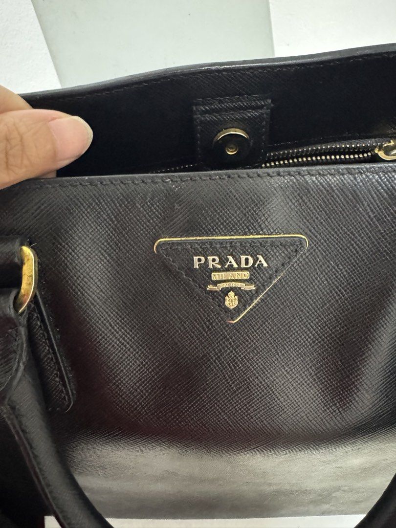Prada Saffiano Leather Large Bag Black (Category: Luxury Bags & Wallets) located in Manila. Submitted by alexandria98225 (Listing ID 1461323285, Image 2). Description: - Certified authentic black Prada Saffiano Large bag - Gold hardware - With signs of usage - no strap and original dustbag Inclusions: - bag organizer - Entrupy certification - generic dust bag only Meet up within Taguig/Makati.