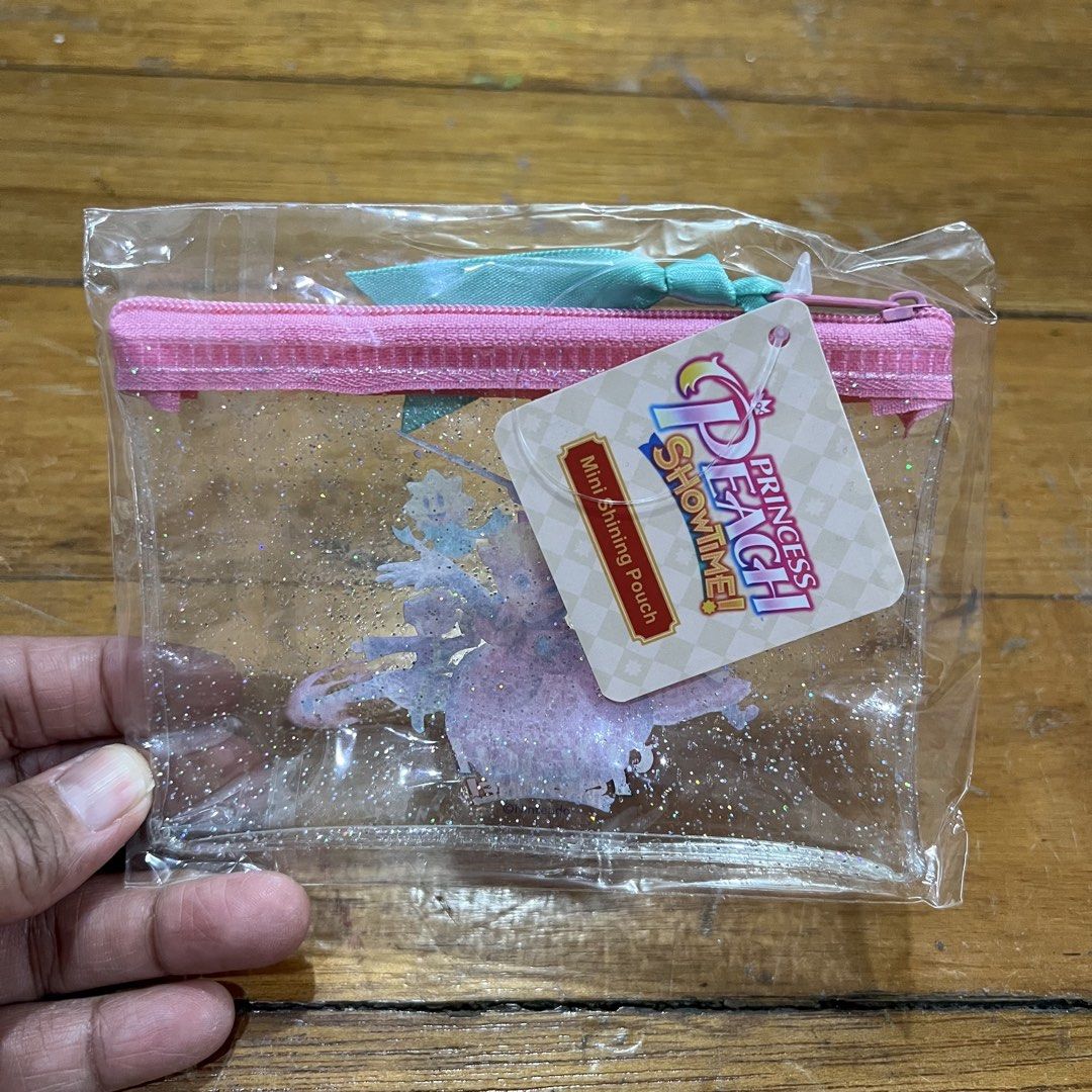 Princess Peach Showtime! Mini Shining Pouch preorder benefit (Category: Nintendo) located in Pasig City. Submitted by annaagra (Listing ID 1461131076, Image 2). Description: -It is a preorder benefit, got it when I bought the game from Data Blitz. -Brand new Never opened, never used - Adorable clear pouch with shimmering glitter - Features beloved Princess Peach and friends - Secure pink zipper closure - Stylish teal ribbon tie - Ideal for organi