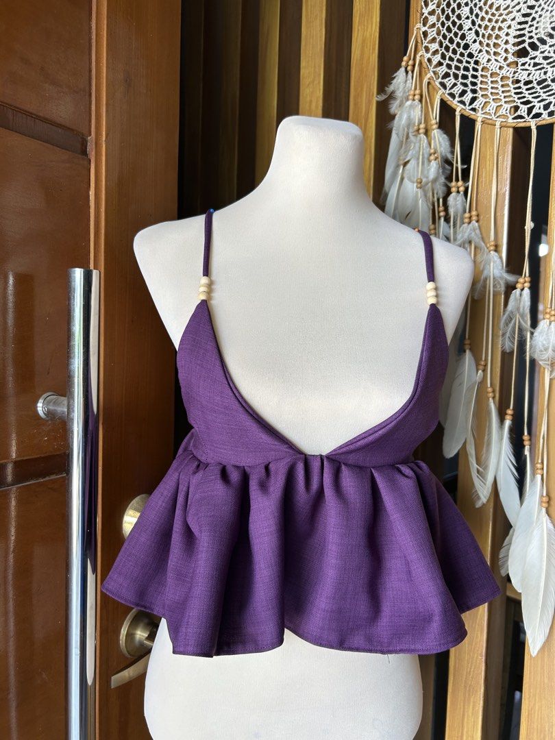 Purple Peplum Crop Top with Beaded Straps (Category: Sleeveless) located in Banaybanay. Submitted by rethread.co (Listing ID 1461117761, Image 2). Description: - Adorable purple peplum crop top - Features adjustable spaghetti straps with charming wooden beads - Fun, flowy peplum hem for a playful silhouette - Ideal for summer days or stylish nights out - Versatile piece: easily pairs with jeans or skirts.
