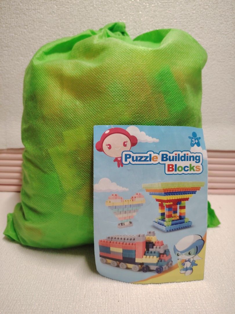 Puzzle Building Blocks Toy with Storage Bag (Category: Educational & Learning Toys) located in Marikina City. Submitted by sedyrah (Listing ID 1461146352, Image 1). Description: - Fun building blocks for kids aged 3 and up. - Encourages creative play and develops fine motor skills. - Comes with a convenient bright green mesh storage bag. - Packaging shows examples of a heart, tower, and train to inspire building ideas..