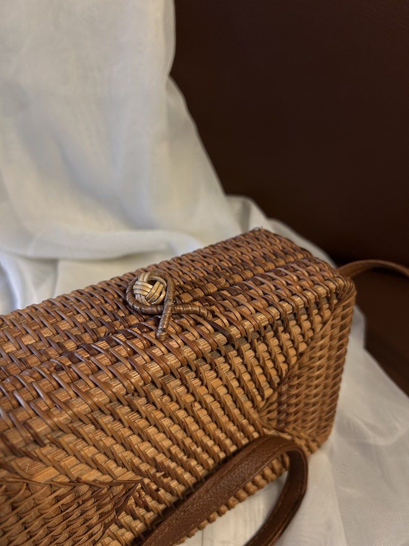 RATTAN SLING BAG (Category: Cross-body Bags) located in Baguio. Submitted by chmlnstudio (Listing ID 1461297269, Image 2). Description: Product Details ✦ Style & Form: Structured rectangular box bag / crossbody shoulder bag Material: ⟡ Hand-woven natural rattan/ata grass body ⟡ Faux leather (tan/brown) shoulder strap ⟡ Soft dark fabric inner lining with side gussets Closure & Hardware: ⟡ Traditional woven rattan loop and knot-button closure ⟡ Sec