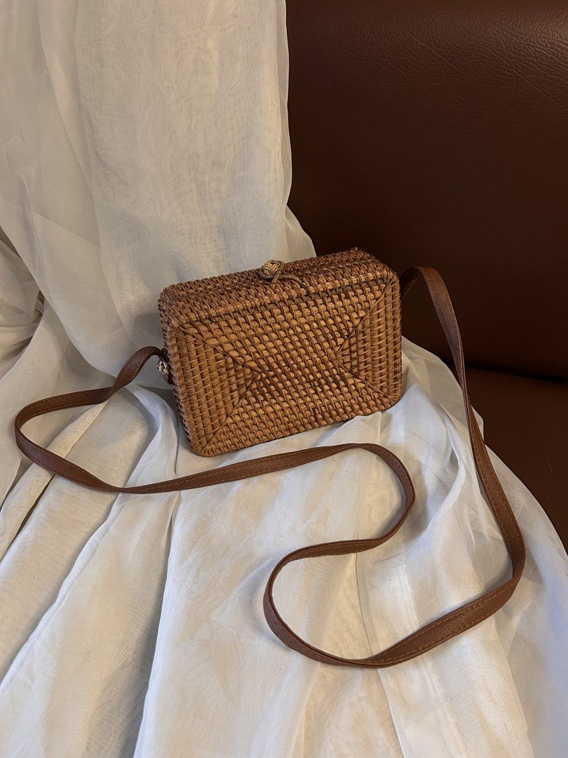 RATTAN SLING BAG (Category: Cross-body Bags) located in Baguio. Submitted by chmlnstudio (Listing ID 1461297269, Image 1). Description: Product Details ✦ Style & Form: Structured rectangular box bag / crossbody shoulder bag Material: ⟡ Hand-woven natural rattan/ata grass body ⟡ Faux leather (tan/brown) shoulder strap ⟡ Soft dark fabric inner lining with side gussets Closure & Hardware: ⟡ Traditional woven rattan loop and knot-button closure ⟡ Sec