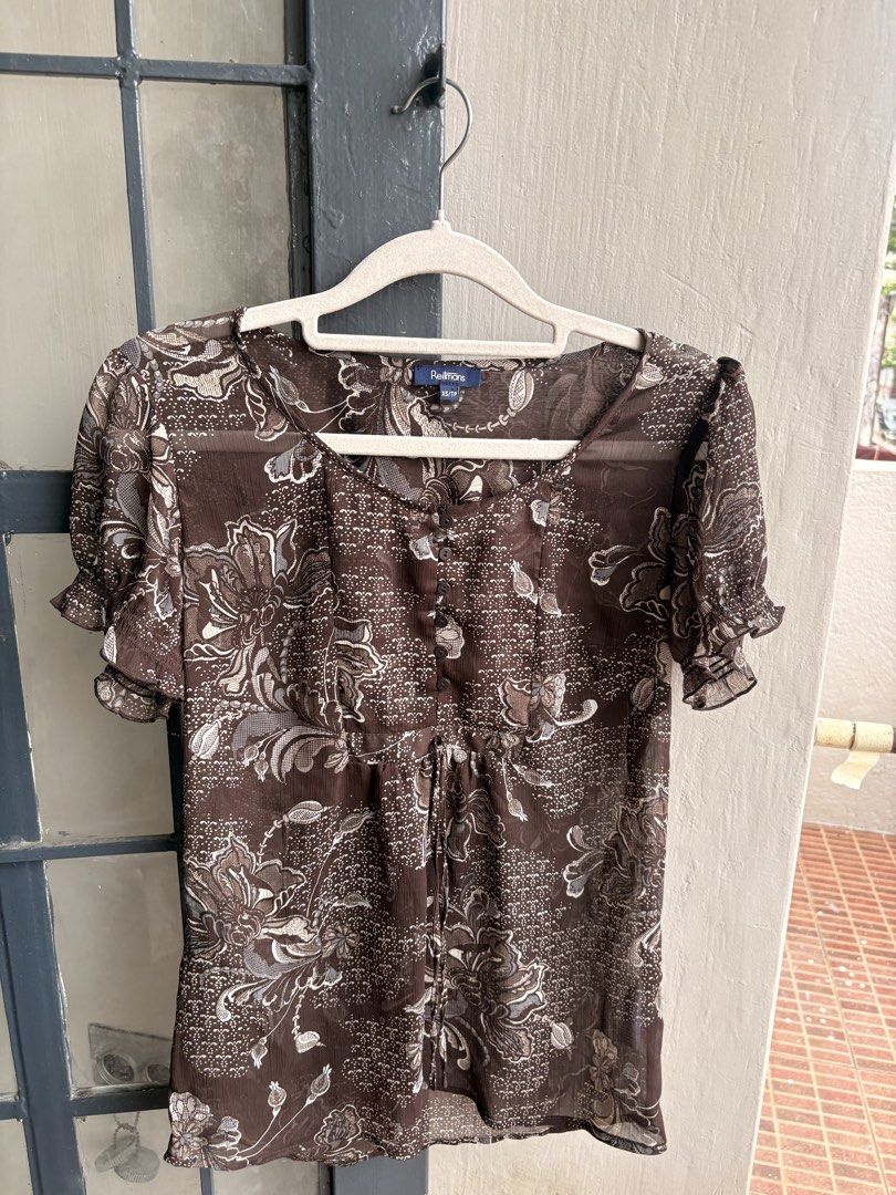 Reitmans Brown Floral Sheer Button-Up Blouse XS/TP (Category: Blouses) located in Cainta. Submitted by declutteringprelovedbyzelle (Listing ID 1461242721, Image 1). Description: - Brand: Reitmans - Color: Brown - Pattern: Floral print - Style: Sheer blouse - Sleeves: Short with ruffled cuffs - Closure: Button-up front - Waist: Drawstring - Fabric: Lightweight and airy - Versatile: Great for layering or wearing alone.