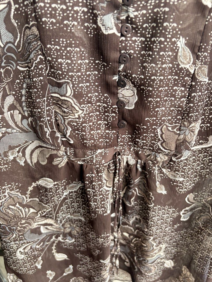 Reitmans Brown Floral Sheer Button-Up Blouse XS/TP (Category: Blouses) located in Cainta. Submitted by declutteringprelovedbyzelle (Listing ID 1461242721, Image 3). Description: - Brand: Reitmans - Color: Brown - Pattern: Floral print - Style: Sheer blouse - Sleeves: Short with ruffled cuffs - Closure: Button-up front - Waist: Drawstring - Fabric: Lightweight and airy - Versatile: Great for layering or wearing alone.