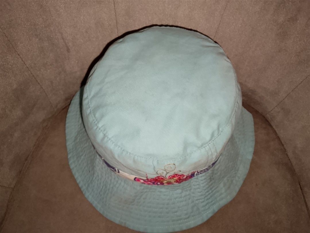 Reversible Bucket Hat (Category: Hats & Beanies) located in Binangonan. Submitted by yuristalin888 (Listing ID 1461307601, Image 3). Description: Stay sun-safe and stylish with this versatile, reversible bucket hat. One side features a classic light blue denim fabric accented by a colorful floral and patterned ribbon band. The other side displays a playful, all-over dark blue floral print on a light background, complemented by a red-and-white che