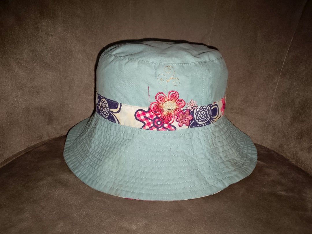 Reversible Bucket Hat (Category: Hats & Beanies) located in Binangonan. Submitted by yuristalin888 (Listing ID 1461307601, Image 2). Description: Stay sun-safe and stylish with this versatile, reversible bucket hat. One side features a classic light blue denim fabric accented by a colorful floral and patterned ribbon band. The other side displays a playful, all-over dark blue floral print on a light background, complemented by a red-and-white che
