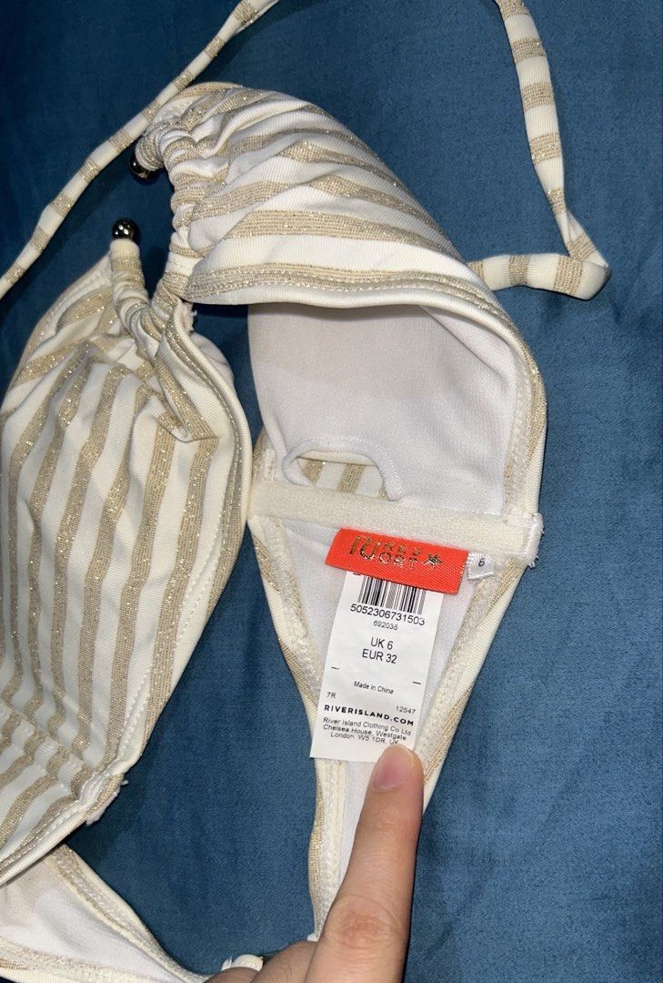 River Island Gold Stripe Ring Halter Bikini Top (Category: Bikinis & Swimsuits) located in Palo. Submitted by kaleidoscope_676 (Listing ID 1461123082, Image 2). Description: - Gold and white striped bikini top - Ring detail at the front - Halter neck strap - Clasp closure at the back - Brand: River Island.