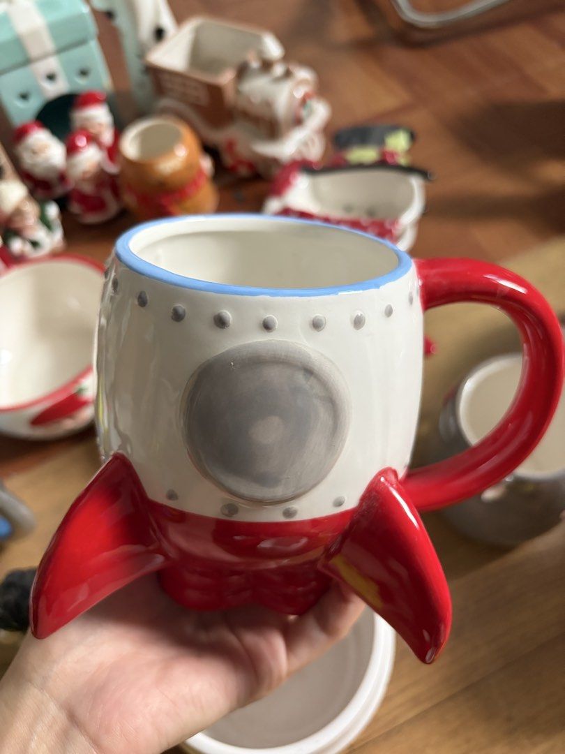 Rocket Ship Mug with Red Fins and Handle (Category: Coffee & Tea Tableware) located in Manila. Submitted by itsandrea (Listing ID 1461291703, Image 1). Description: - Fun rocket ship design - White mug with red fins and handle - Blue trim around the top rim - Features a grey circular window detail - Ideal for coffee or tea - Unique gift for space enthusiasts.
