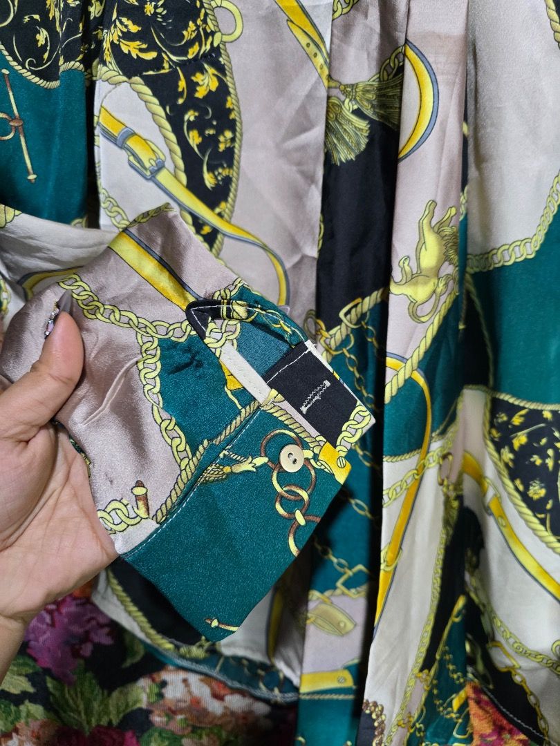 Satin Scarf Neck Blouse with Chain Print (Category: Blouses) located in Paranaque City. Submitted by titaartestudio (Listing ID 1461189762, Image 3). Description: - Silky satin blouse - Bold chain and baroque print - Tie-neck detail - Button-up front - Long sleeves with button cuffs - Comfortable and stylish for any occasion.