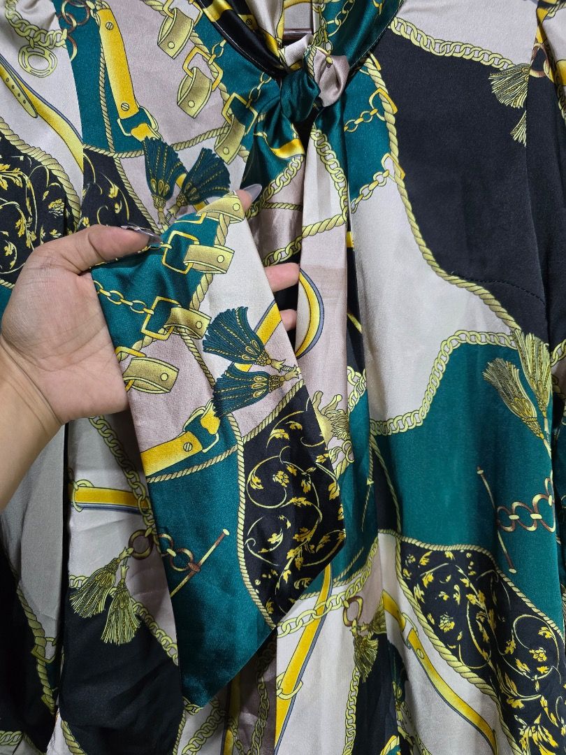 Satin Scarf Neck Blouse with Chain Print (Category: Blouses) located in Paranaque City. Submitted by titaartestudio (Listing ID 1461189762, Image 2). Description: - Silky satin blouse - Bold chain and baroque print - Tie-neck detail - Button-up front - Long sleeves with button cuffs - Comfortable and stylish for any occasion.