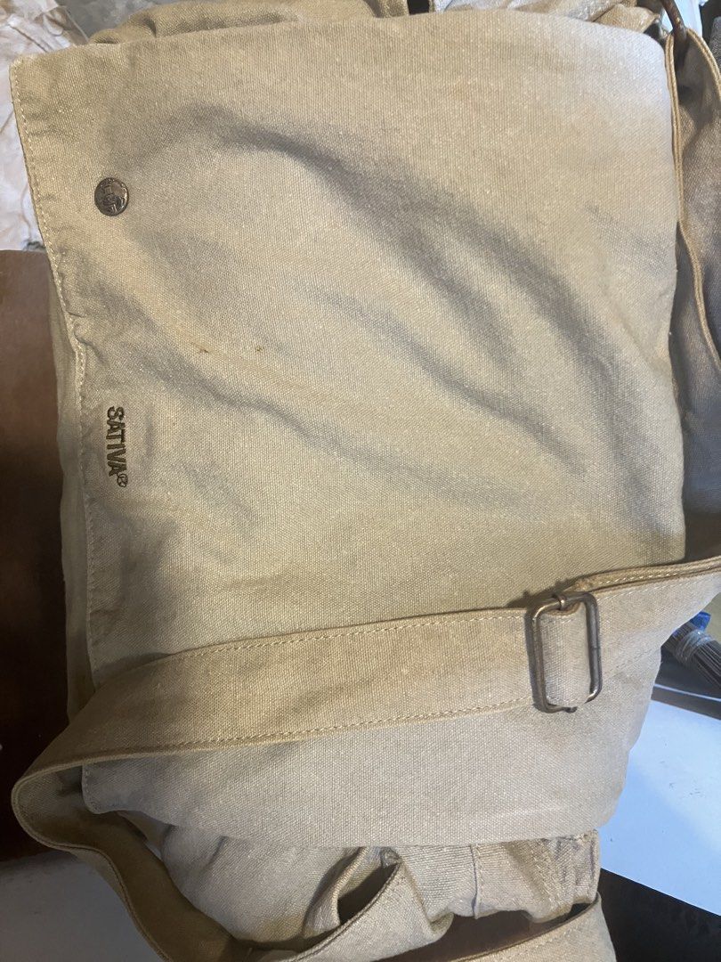 SATIVA Canvas Messenger Bag (ORIGINAL) (Category: Sling Bags) located in Quezon City. Submitted by ponpin (Listing ID 1461154208, Image 2). Description: - SATIVA messenger bag - Neutral light green color - Durable canvas material - Main compartment with zip closure - Internal pockets for organization - Exterior pocket with button closure - Adjustable strap for comfortable carrying - Ideal for everyday use Issue - Rust discoloration Negotiable pri
