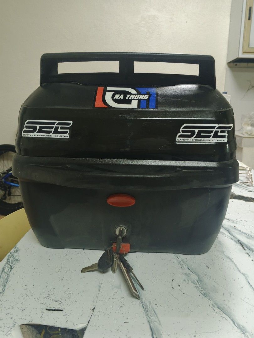 SEC Motorcycle Top Box with Keys (Category: Other Motorcycles Parts and Accessories) located in Manila. Submitted by annecbau (Listing ID 1461218215, Image 1). Description: SEC motorcycle top box with 'Na Thong' and 'K-Workz Team' stickers. Includes keys. Spacious for your essentials. Mounts on your motorcycle rack. Ideal for daily rides and longer trips. 36 liters.