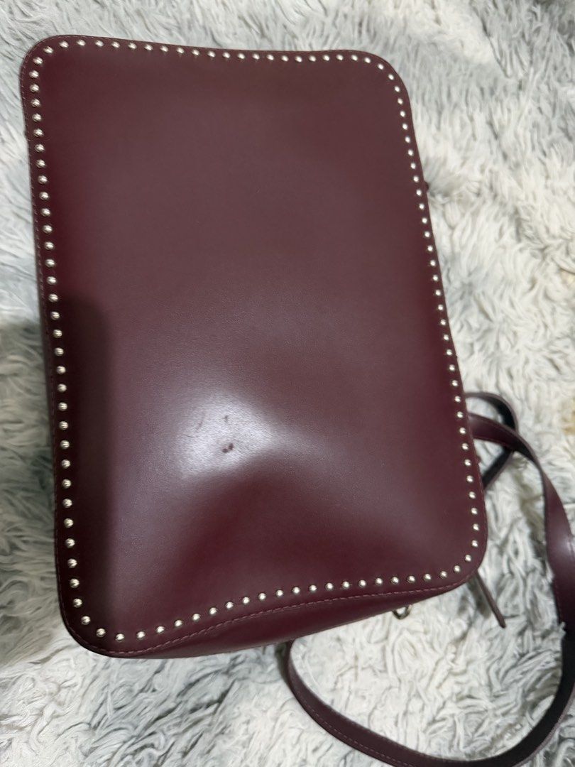 Sequoia Genuine Leather Bag (Category: Shoulder Bags) located in San Mateo. Submitted by swammies (Listing ID 1461248327, Image 2). Description: - Stylish burgundy leather handbag - Edgy studded detailing along the edges - Versatile with top handles and a detachable shoulder strap - Secure zipper closure to keep your belongings safe - Convenient interior zipped pocket for essentials - Minor marks on the exterior, adding character - Ideal for ever