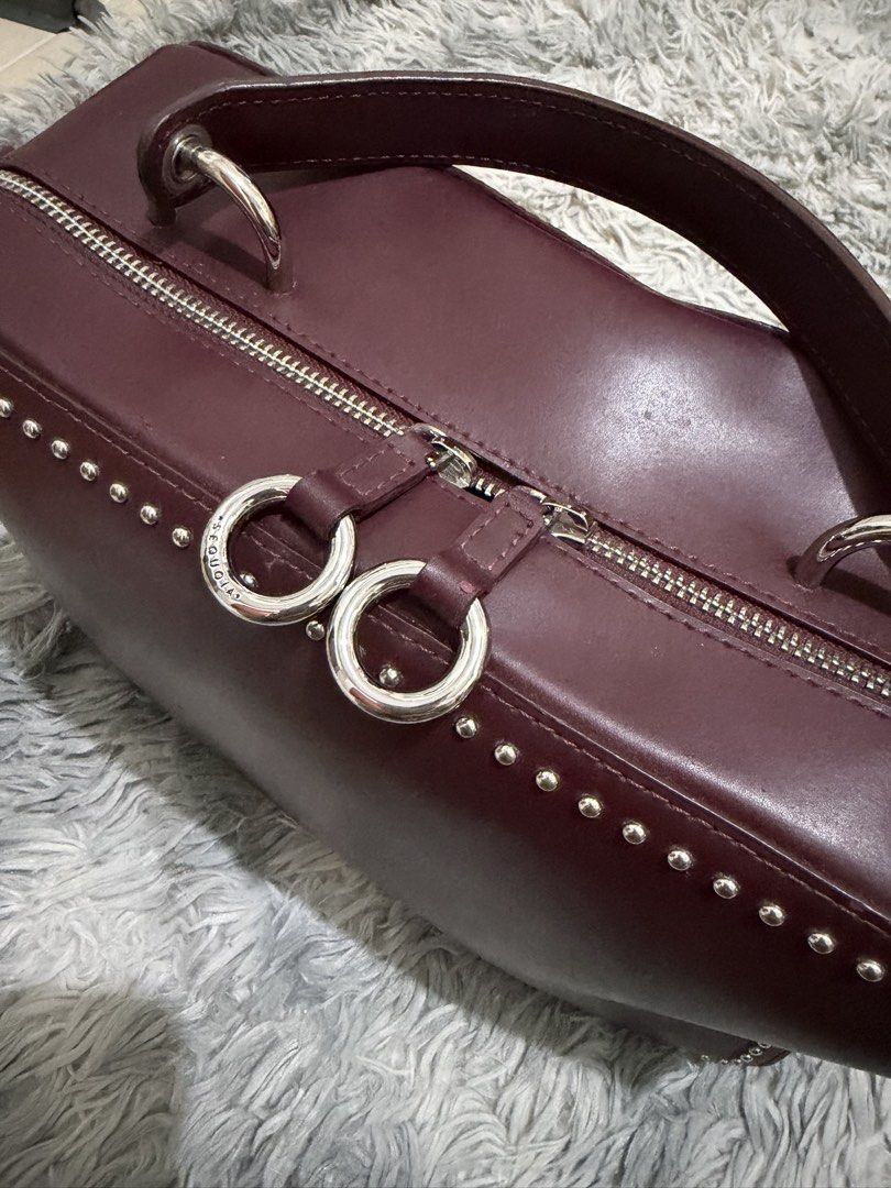 Sequoia Genuine Leather Bag (Category: Shoulder Bags) located in San Mateo. Submitted by swammies (Listing ID 1461248327, Image 3). Description: - Stylish burgundy leather handbag - Edgy studded detailing along the edges - Versatile with top handles and a detachable shoulder strap - Secure zipper closure to keep your belongings safe - Convenient interior zipped pocket for essentials - Minor marks on the exterior, adding character - Ideal for ever