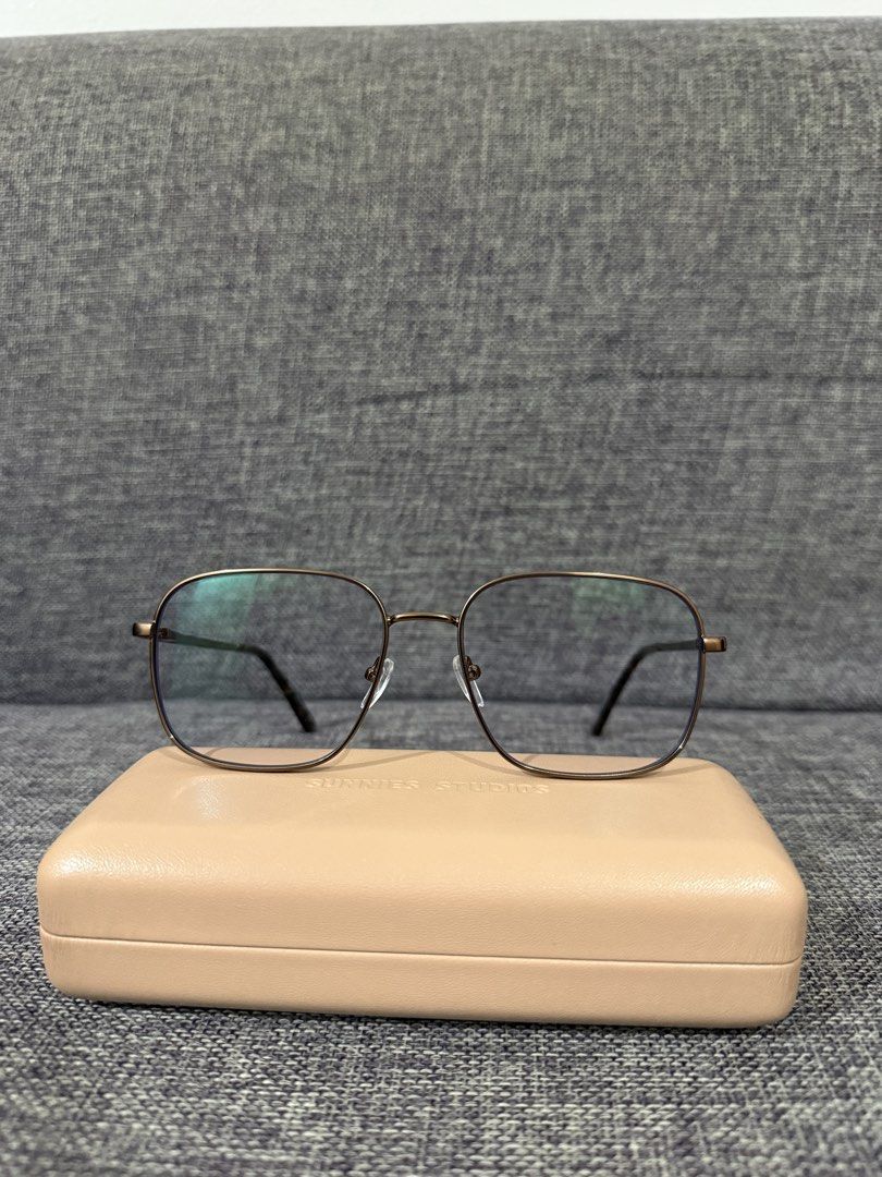 Sunnies Anti-Rad Glasses (Category: Sunglasses & Eyewear) located in Manila. Submitted by hannabananahhh (Listing ID 1461295761, Image 2). Description: - Geometric frame design - Dark metallic frame color - Lenses with a subtle blue tint - Comes with a light pink protective case - Ideal for everyday wear or as a fashion statement.
