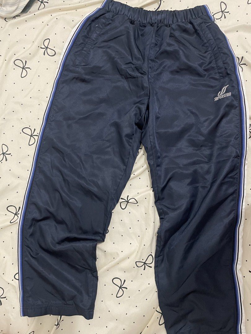 Superstar Navy Blue Track Pants Size S (Category: Other Bottoms) located in Manila. Submitted by puredolphin_e419e1 (Listing ID 1461257957, Image 1). Description: - Navy blue Superstar track pants - White and blue stripes down the sides - Elastic waistband with drawstring - Size S - Ideal for sports or casual wear - Please check photos for detailed condition.