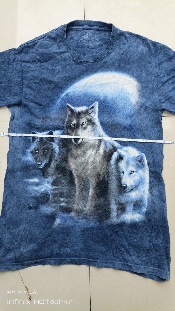 The Mountain Wolf Pack T-Shirt (Category: Tshirts & Polo Shirts ) located in Manila. Submitted by treblig. (Listing ID 1461240313, Image 2). Description: - Cool blue tie-dye t-shirt - Features a striking wolf pack graphic under a moonlit sky - Authentic The Mountain brand - Size S - Ideal for casual wear.