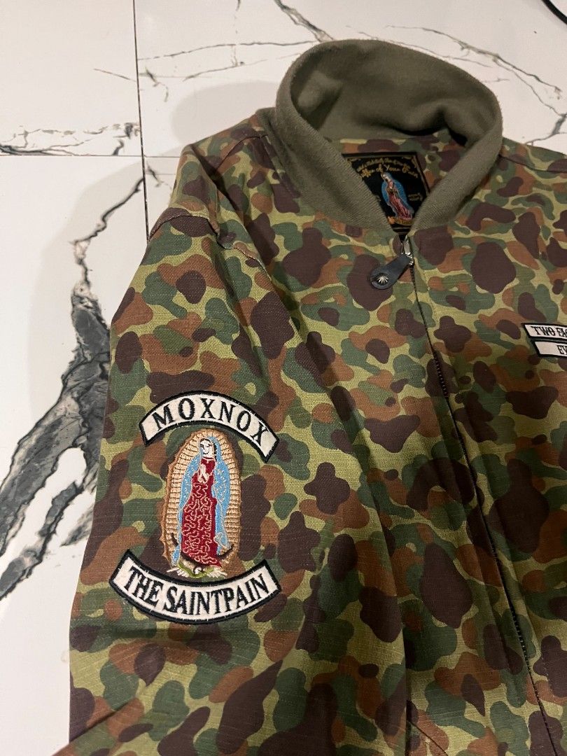 Two Face Saints Camo Bomber Jacket Evil + Holy (Category: Coats, Jackets and Outerwear) located in Manila. Submitted by yodskie00 (Listing ID 1461266104, Image 3). Description: - Camo bomber jacket by Two Face Saints - Patches on chest and sleeve - Zippered pocket on the arm - Ribbed collar, cuffs, and hem - Ideal for casual outfits.