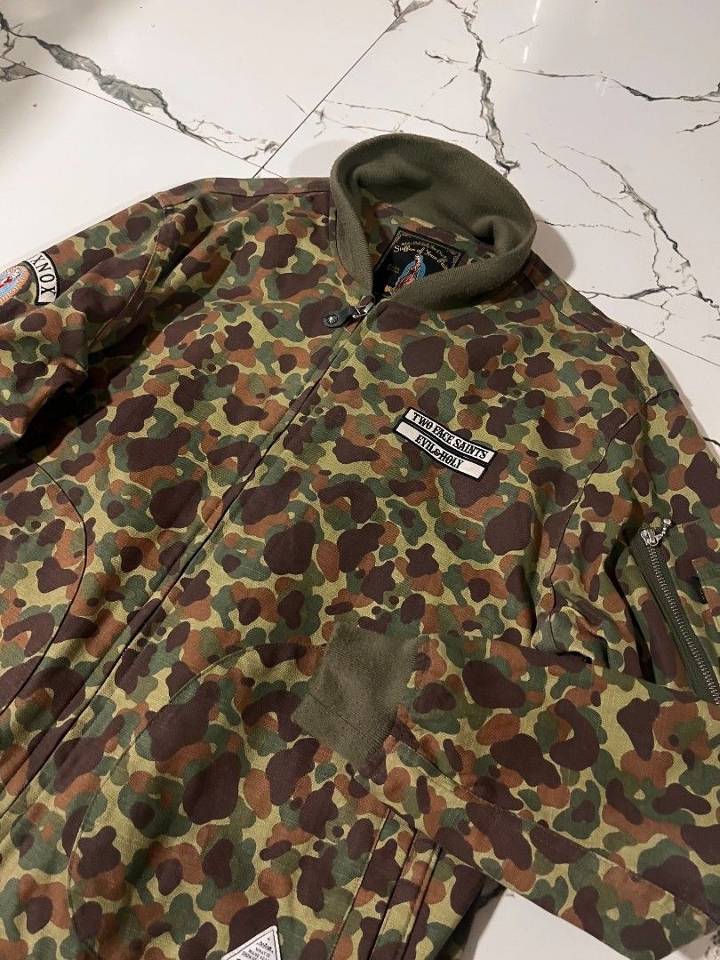 Two Face Saints Camo Bomber Jacket Evil + Holy (Category: Coats, Jackets and Outerwear) located in Manila. Submitted by yodskie00 (Listing ID 1461266104, Image 2). Description: - Camo bomber jacket by Two Face Saints - Patches on chest and sleeve - Zippered pocket on the arm - Ribbed collar, cuffs, and hem - Ideal for casual outfits.