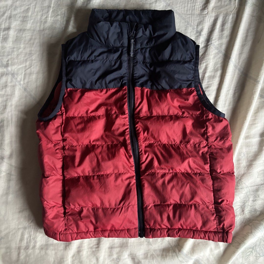 Uniqlo Kids Puffer Padded Warm Vest (Category: Coats, Jackets and Outerwear) located in Binan City. Submitted by myprelovedhaul (Listing ID 1461217708, Image 2). Description: Fits adult xs frame The item in the image is a Uniqlo Kids Light Warm Padded Puffer Vest. It features a distinctive two-tone colorblock design with a dark navy/black shoulder yoke paired with a bold red lower body..