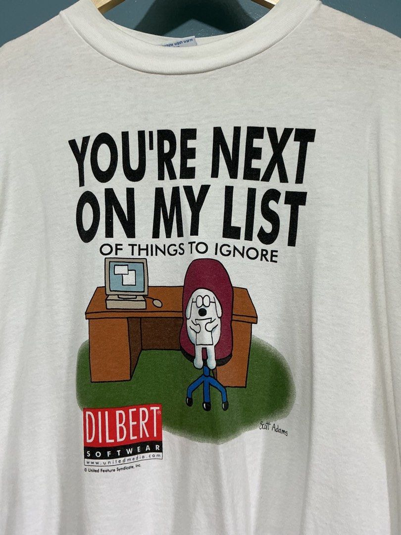 Vintage 1990s Dilbert Dogbert Comic T-Shirt (Category: Tshirts & Polo Shirts ) located in Bulacan. Submitted by garmentsbyadi. (Listing ID 1460050341, Image 2). Description: - 24x30 - Single stitch all the way - All sports tag This graphic t-shirt features Dogbert from Scott Adams’ syndicated comic strip Dilbert, which became a cultural touchstone of 1990s corporate and tech office culture. Produced under official license by United Feature Syndic
