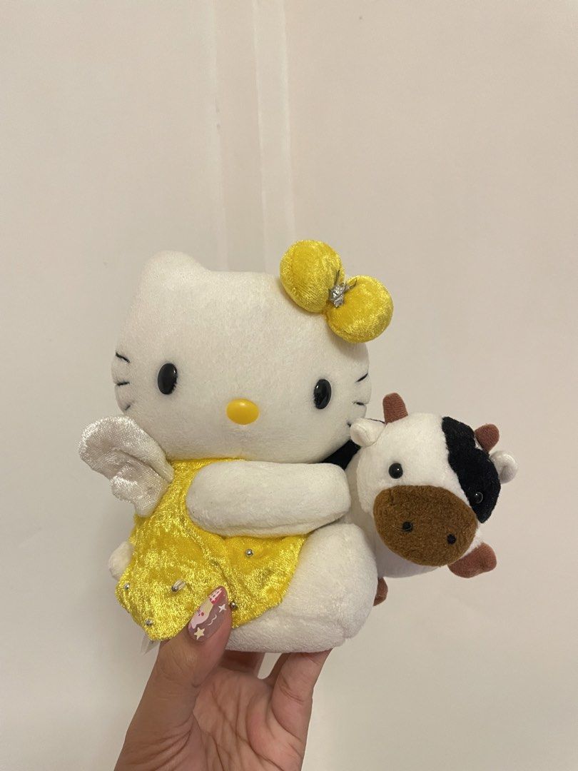 Vintage 2000 Hello Kitty Zodiac (Category: Plushies & Soft Toys) located in Iba. Submitted by wealtheallymari99 (Listing ID 1461116175, Image 1). Description: - Adorable Kitty plush toy - Features a sparkly yellow dress and white wings - Includes a small cow plushie that she's holding - Ideal for Kitty collectors - Makes a wonderful gift for fans.