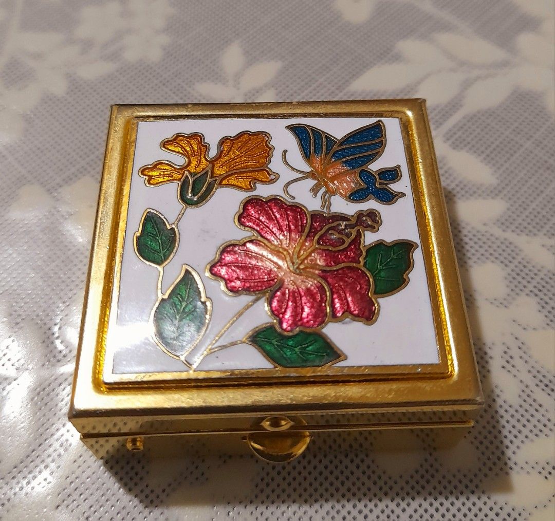 Vintage Cloisonnè Enamel Trinket Box (Category: Other Home Decor) located in Manila. Submitted by miamiga (Listing ID 1461226554, Image 1). Description: Size: 1.5" (L) × 1.5" (W) × 0.5" (H) - Square gold-tone trinket box - Decorated with cloisonnè flowers and a butterfly - With removable container inside - Ideal for pills, mints, or other tiny keepsakes - Compact and portable design - Secure clasp closure - With visible scratches.