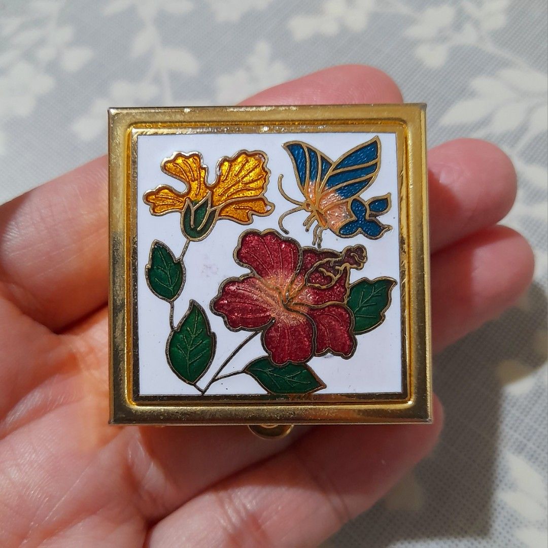 Vintage Cloisonnè Enamel Trinket Box (Category: Other Home Decor) located in Manila. Submitted by miamiga (Listing ID 1461226554, Image 3). Description: Size: 1.5" (L) × 1.5" (W) × 0.5" (H) - Square gold-tone trinket box - Decorated with cloisonnè flowers and a butterfly - With removable container inside - Ideal for pills, mints, or other tiny keepsakes - Compact and portable design - Secure clasp closure - With visible scratches.