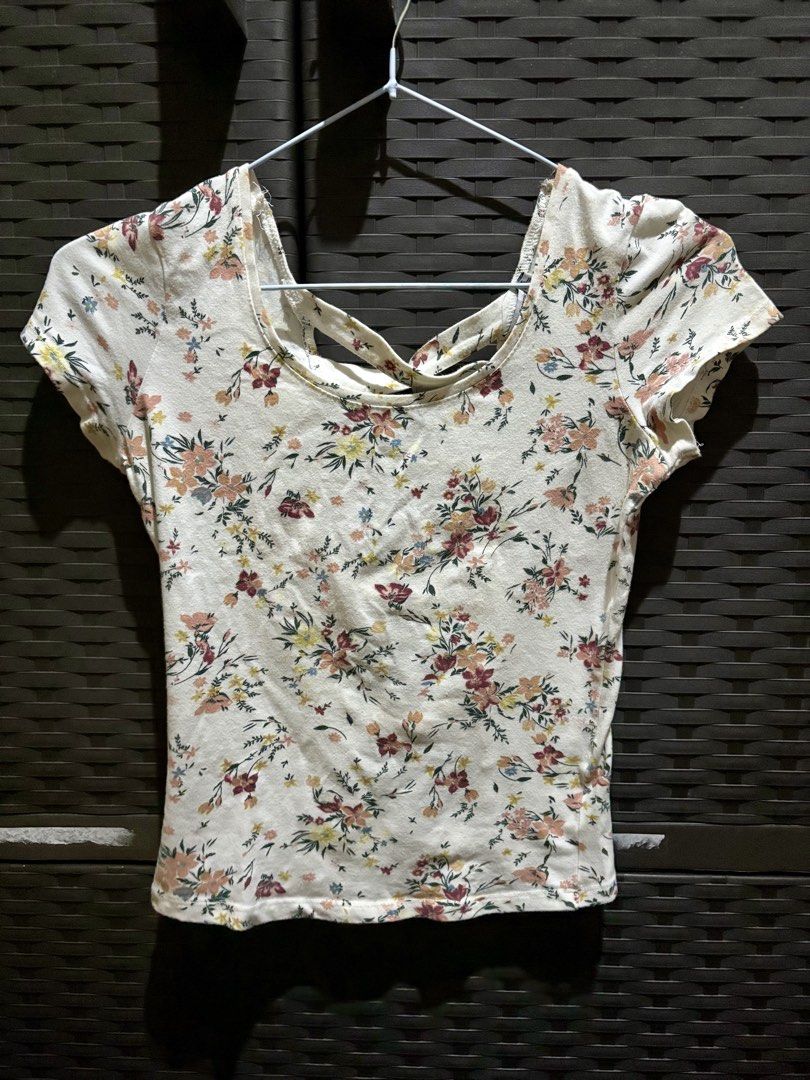 White Floral Printed Shirt Top (Category: Blouses) located in Marikina City. Submitted by senandash (Listing ID 1461303458, Image 1). Description: XS-S - Cute white top with a pretty floral print. - Features short sleeves. - Unique back cut-out detail with criss-cross straps. - Versatile: pairs well with jeans or shorts. - Ideal for casual outings and days with friends..