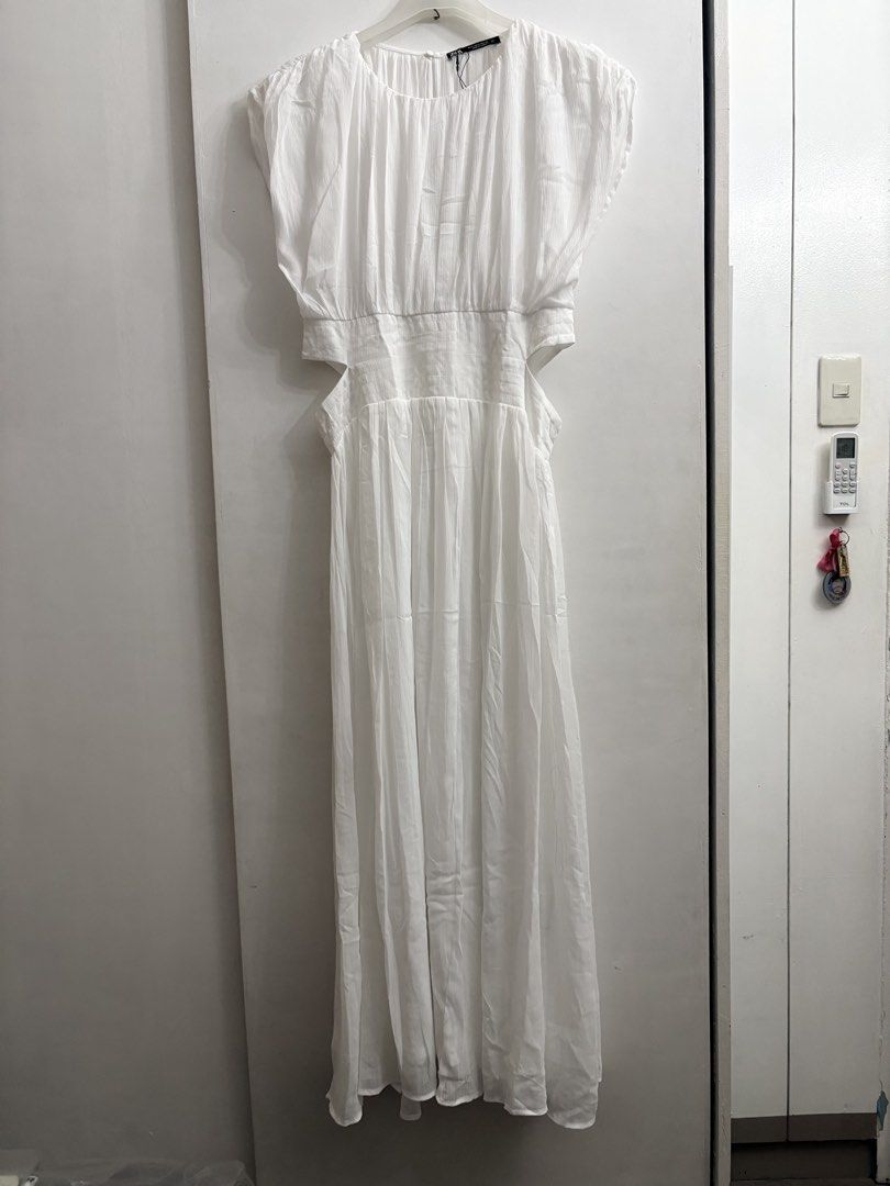 ZARA White Cut-out Maxi Dress (Category: Dresses) located in Quezon City. Submitted by thebutingthings (Listing ID 1461277019, Image 1). Description: - ZARA White Maxi Dress - Features stylish cut-outs at the waist - Short sleeves and a flowy skirt for a breezy feel - Convenient button closure at the back - Proudly made in Turkey - Ideal for beach vacations or summer outings.