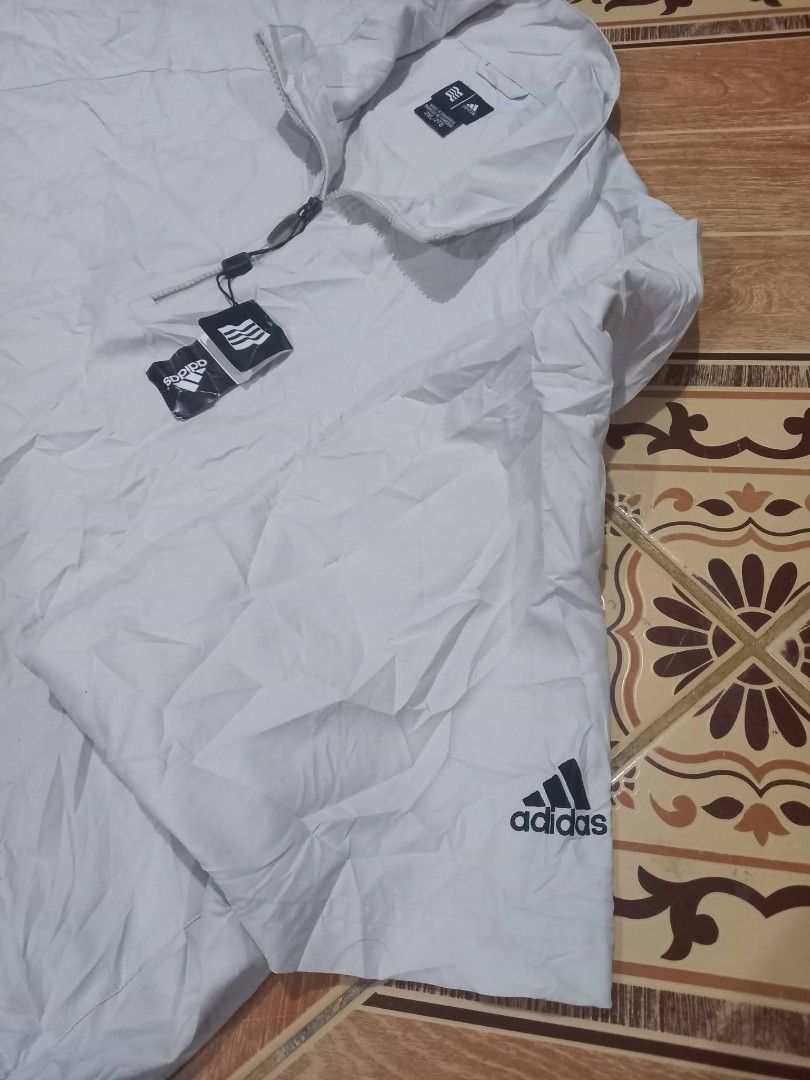 Adidas Lightweight Pullover Jacket (Category: Coats, Jackets and Outerwear) located in Baguio. Submitted by jiannisthriftfits (Listing ID 1461560908, Image 3). Description: - Adidas jacket in a light beige color. - Features a quarter zip closure. - Short sleeves for a comfortable fit. - Convenient side pockets. - Adidas logo prominently displayed on the chest and sleeve. - Made in Cambodia. - Size: 2XL/2TG.