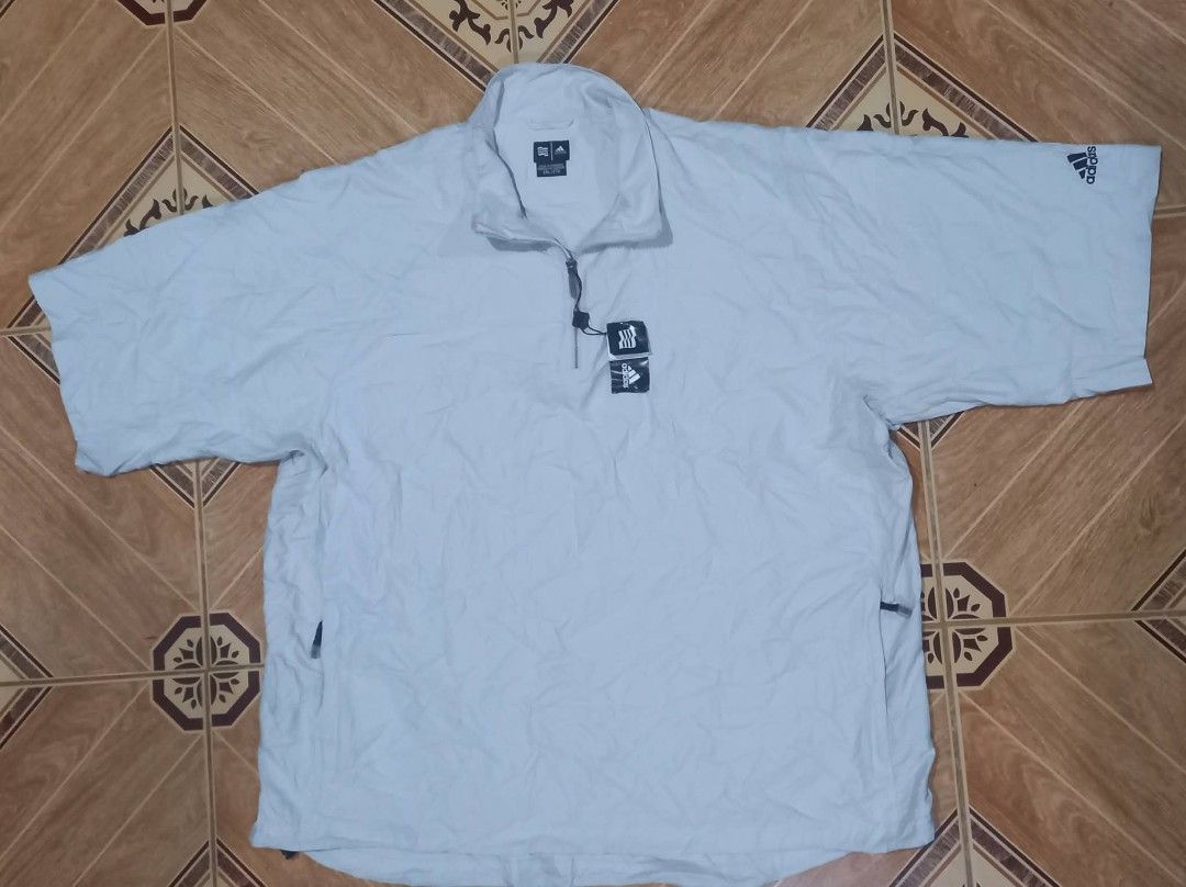 Adidas Lightweight Pullover Jacket (Category: Coats, Jackets and Outerwear) located in Baguio. Submitted by jiannisthriftfits (Listing ID 1461560908, Image 2). Description: - Adidas jacket in a light beige color. - Features a quarter zip closure. - Short sleeves for a comfortable fit. - Convenient side pockets. - Adidas logo prominently displayed on the chest and sleeve. - Made in Cambodia. - Size: 2XL/2TG.