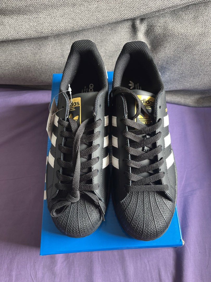 Adidas Superstar (Top grade) (Category: Sneakers) located in Manila. Submitted by gelfaves (Listing ID 1461415416, Image 2). Description: - Classic Adidas Superstar sneakers - Color: Black with white stripes - Iconic shell toe design - Ideal for everyday wear - Comes with original box - Made in Indonesia - Size: UK 8 / EU 41 / JPN 260 TOP GRADE .