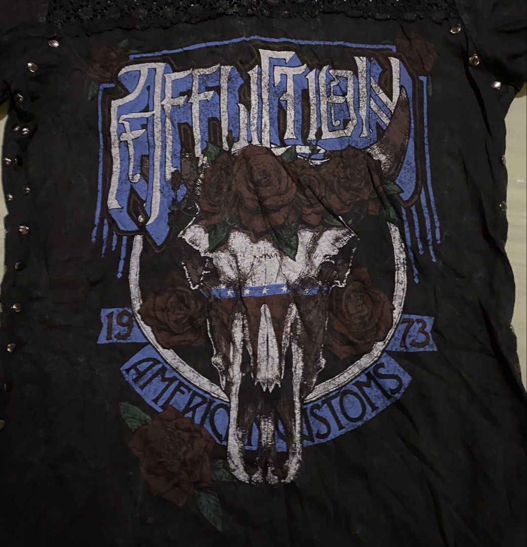 Affliction American Customs T-shirt (Category: Shirts) located in San Carlos City. Submitted by roseee_012 (Listing ID 1461468954, Image 2). Description: - Brand: Affliction - Color: Black - Size: Medium (M) - Design: Cool skull and roses graphic - Details: Lace trim around neckline, studded accents on sides - Material: 100% Cotton - Style: Ideal for a rock or biker aesthetic.
