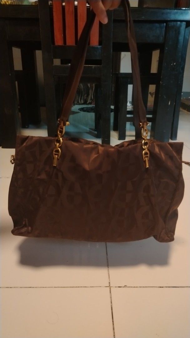 Aigner Monogram Tote Bag Brown (Category: Luxury Bags & Wallets) located in Manila. Submitted by wildwind_73f77a (Listing ID 1461503923, Image 1). Description: - Authentic brown Aigner tote bag - All-over signature monogram pattern - Elegant gold hardware details on straps - Spacious interior with multiple compartments - Includes a secure zip pocket - Expertly crafted in Italy - Ideal for carrying daily essentials.