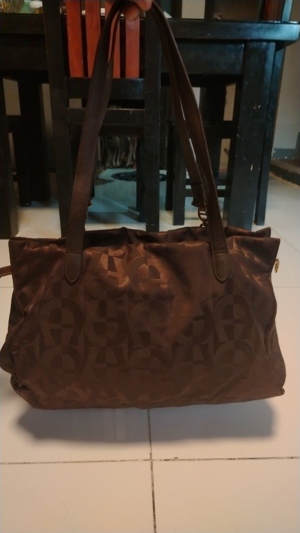 Aigner Monogram Tote Bag Brown (Category: Luxury Bags & Wallets) located in Manila. Submitted by wildwind_73f77a (Listing ID 1461503923, Image 3). Description: - Authentic brown Aigner tote bag - All-over signature monogram pattern - Elegant gold hardware details on straps - Spacious interior with multiple compartments - Includes a secure zip pocket - Expertly crafted in Italy - Ideal for carrying daily essentials.