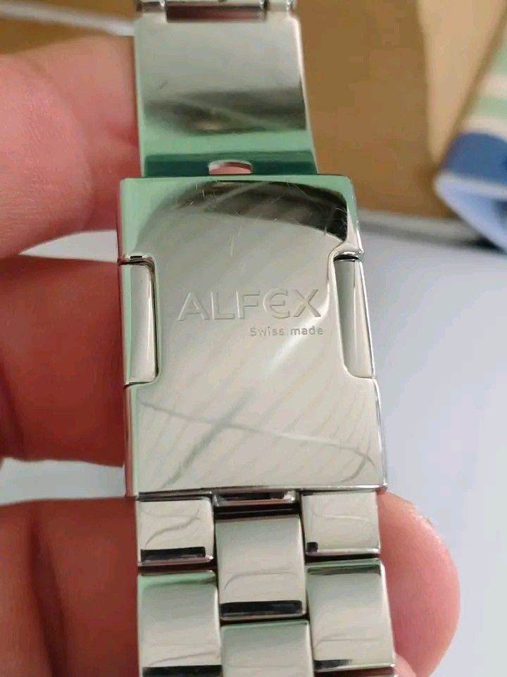 Alfex Swiss Made Rectangular Watch (Category: Men's Watches) located in Manila. Submitted by rsbshop1129 (Listing ID 1461341099, Image 3). Description: - Rectangular watch with stainless steel band - White dial featuring elegant Roman numerals - Convenient date window at 6 o'clock - Authentic Swiss-made quality - Timeless design suitable for daily wear or formal events.