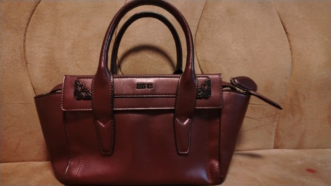 ANNA SUI Burgundy Leather Top Handle Bag (Category: Purses & Pouches) located in Manila. Submitted by wildwind_73f77a (Listing ID 1461503506, Image 1). Description: - Authentic ANNA SUI burgundy leather handbag - Unique patterned interior lining - Secure zipper closure - Two comfortable top handles - Protective metal studs on the bottom - Versatile for everyday or special occasions.