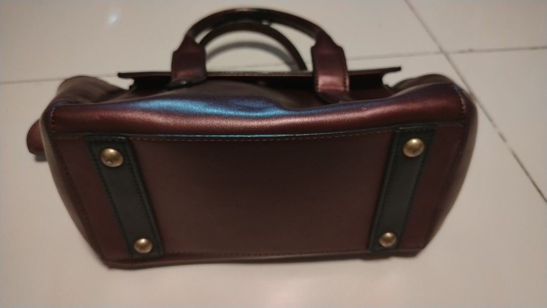 ANNA SUI Burgundy Leather Top Handle Bag (Category: Purses & Pouches) located in Manila. Submitted by wildwind_73f77a (Listing ID 1461503506, Image 2). Description: - Authentic ANNA SUI burgundy leather handbag - Unique patterned interior lining - Secure zipper closure - Two comfortable top handles - Protective metal studs on the bottom - Versatile for everyday or special occasions.