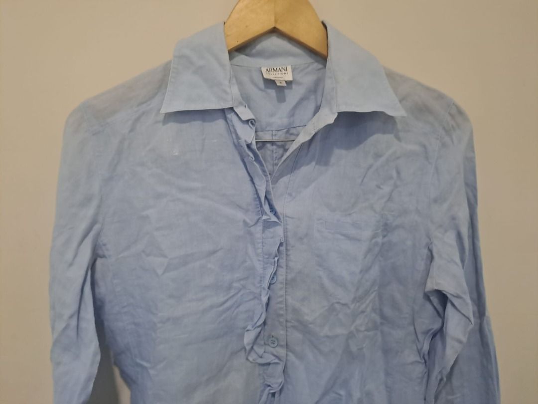 Armani linen longsleeve (Category: Longsleeves) located in Mandaluyong City. Submitted by epicowl-c93c (Listing ID 1461352198, Image 2). Description: This is an Armani Collezioni light blue linen blouse featuring a classic collar, button-up front, and distinct raw-edge ruffle detailing along the central placket and hemline..