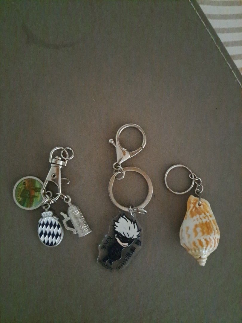 Assorted Keychains (Category: Character Goods) located in Singapore. Submitted by 10714 (Listing ID 1461334975, Image 1). Description: Set of 3 unique keychains: seashell, anime character, and checkered metal charm keychains bought fr Germany. Perfect for bags and keys..