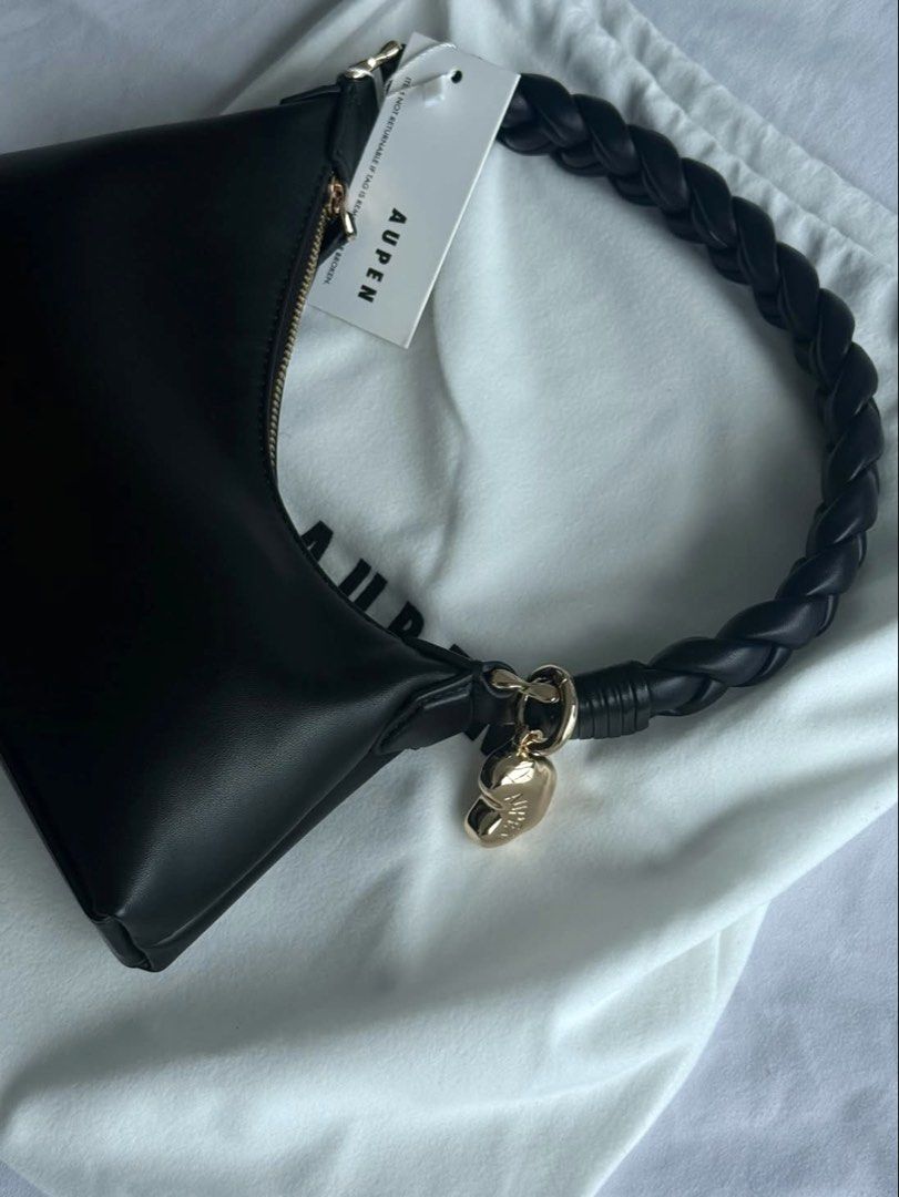 AUPEN Black Leather Shoulder Bag with Braided Handle (Category: Shoulder Bags) located in Quezon City. Submitted by jhosephllorente (Listing ID 1461452472, Image 2). Description: - Chic AUPEN black shoulder bag - Unique braided handle - Elegant gold charm detail - Comes with original dust bag - Versatile: Great for everyday use or a night out - Minimalist and stylish design.